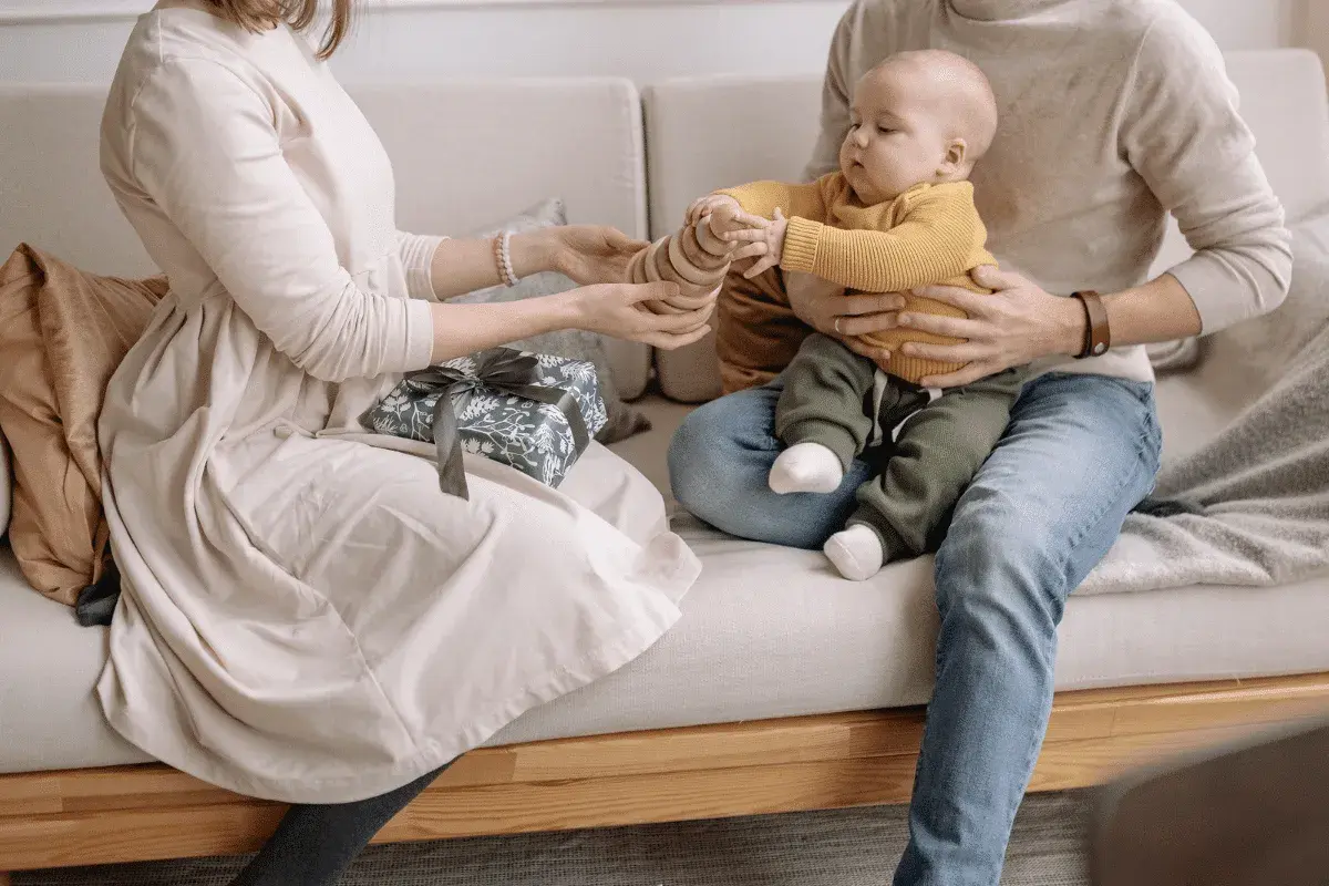 Un couple heureux profite de son enfant, un cadeau emballé à côté.