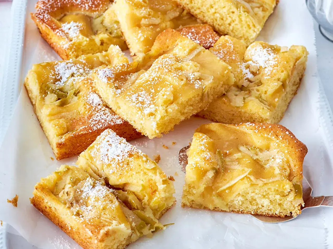 Saftiger Apfelkuchen mit Apfelmus, bestäubt mit Puderzucker. Ein köstlicher Genuss für jeden Anlass.