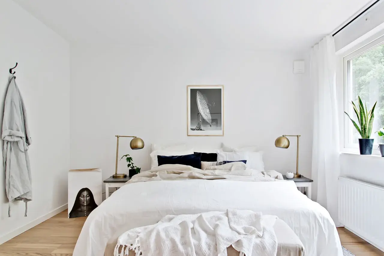 Ett ljust och luftigt sovrum med stor säng, konst och växter. En känsla av lugn och harmoni som passar bra för feng shui sovrum.