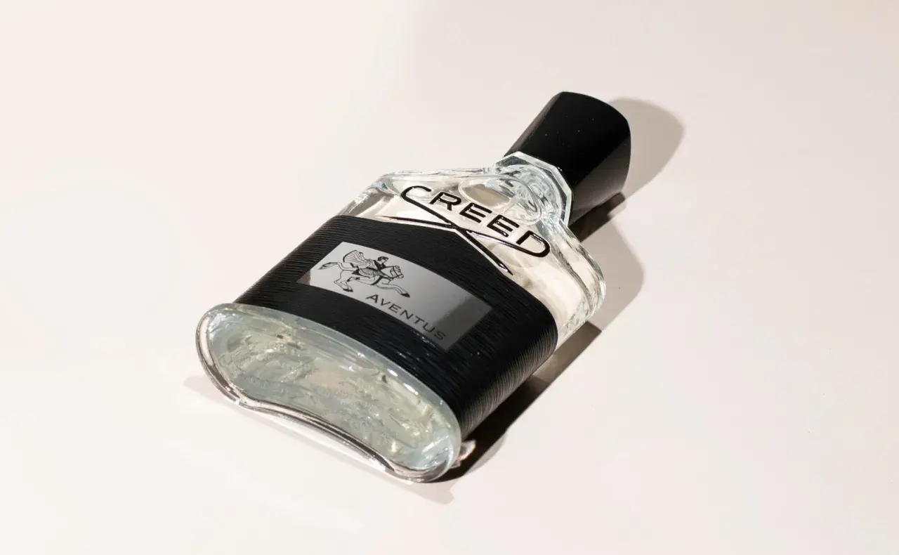 Elegancka butelka perfum Aventus Creed z czarną opaską i wizerunkiem jeźdźca.