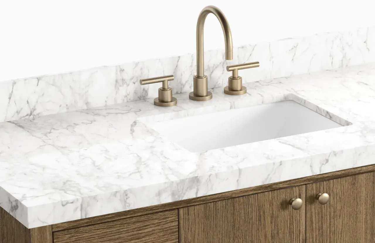 A modern bathroom vanity with a white sink, brass faucet, and a white marble countertop. This image showcases a stylish option to replace bathroom countertop.