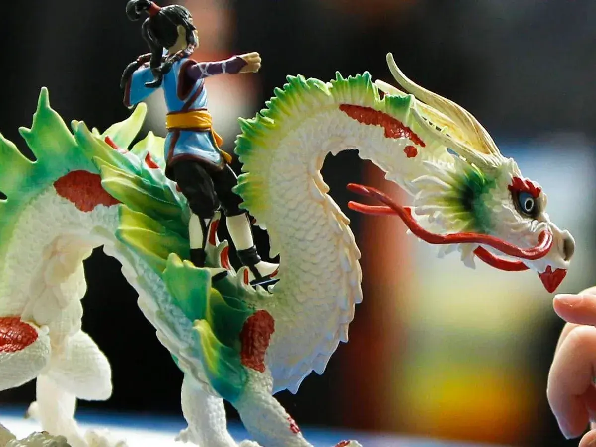Ein Junge reitet auf einem weißen Drachen mit grünen und roten Akzenten. Ein detailreiches Schleich Spielzeug, das Fantasie und Abenteuer weckt.