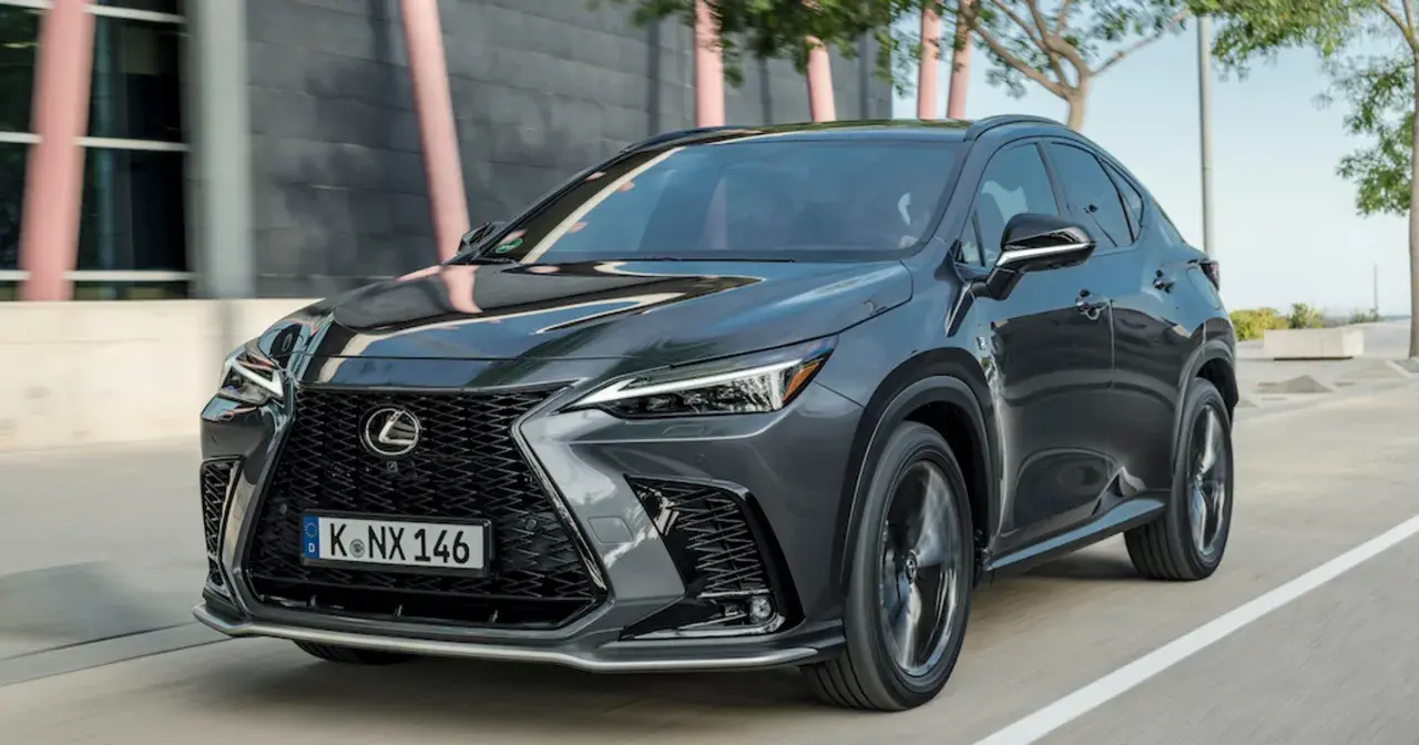 Elegancki, ciemnoszary Lexus NX 350h w ruchu ulicznym, z charakterystycznym grillem i ostrymi światłami.