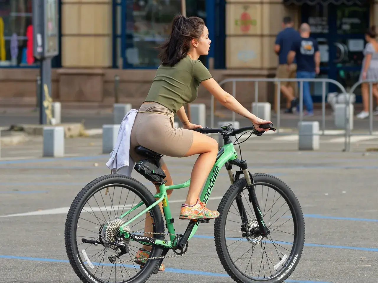 Dziewczyna na rowerze, która uczy się, jak zmieniać przerzutki w rowerze, by jazda była płynniejsza.