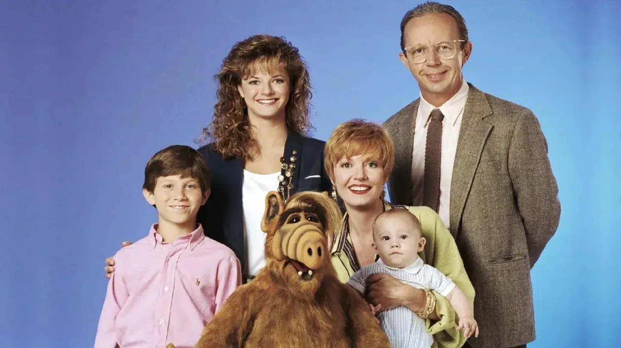 Familjen Tanner poserar med ALF. Rollistan i ALF inkluderar Max Wright, Anne Schedeen, Andrea Elson, Benji Gregory och dockan ALF.