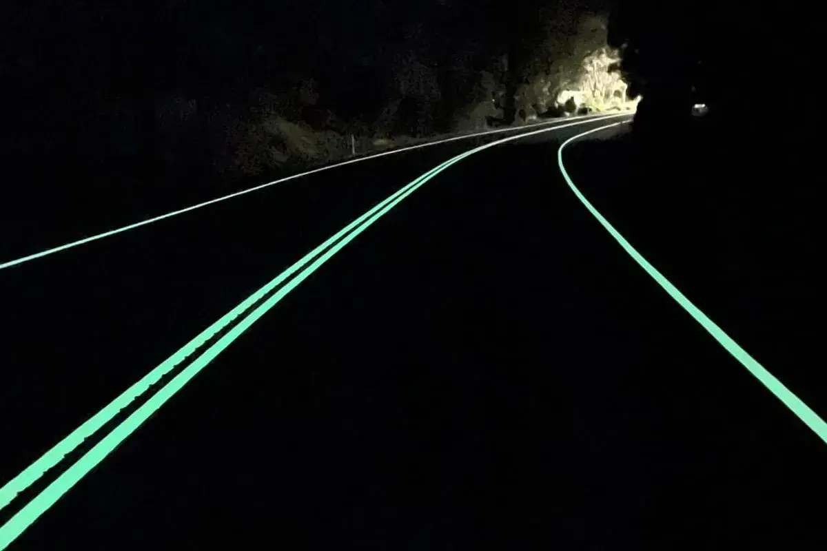 Route de nuit avec marquage lumineux vert, un logo marquage ce discret sur le côté.