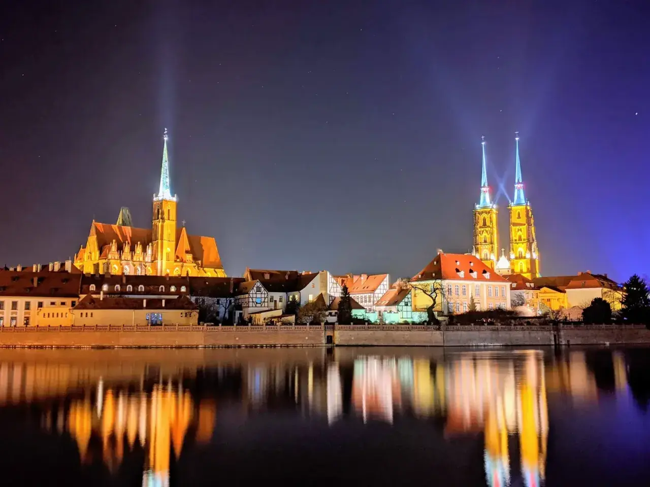 Beleuchtete Kathedralen spiegeln sich im Wasser. Ein perfekter Anblick nach einer Wrocław free walking tour.