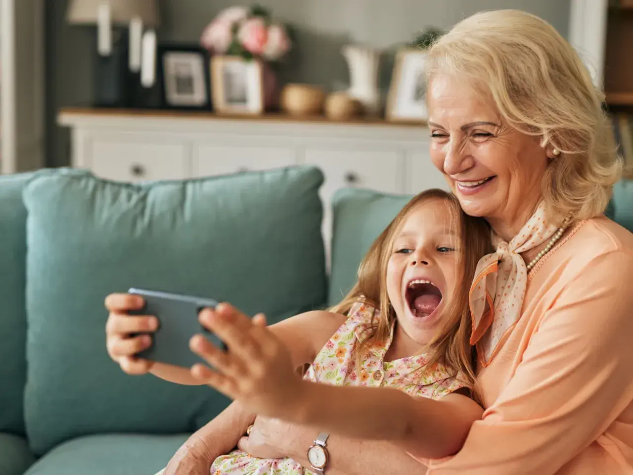 Großmutter und enkel kinder machen ein Selfie. Sie lachen beide vor Freude.