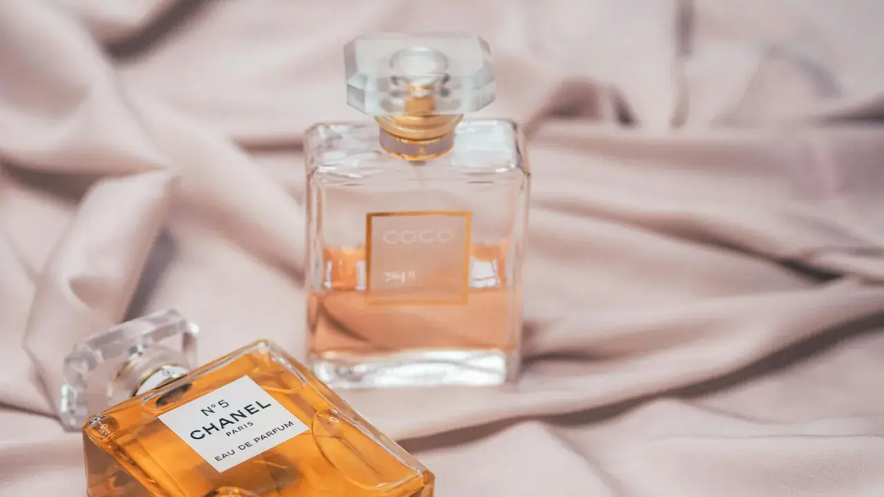 Dwie ikoniczne butelki perfum Chanel, N°5 i Coco Mademoiselle, na jedwabistym tle. Klasyka, która nigdy nie wychodzi z mody, jak Chanel Noir.