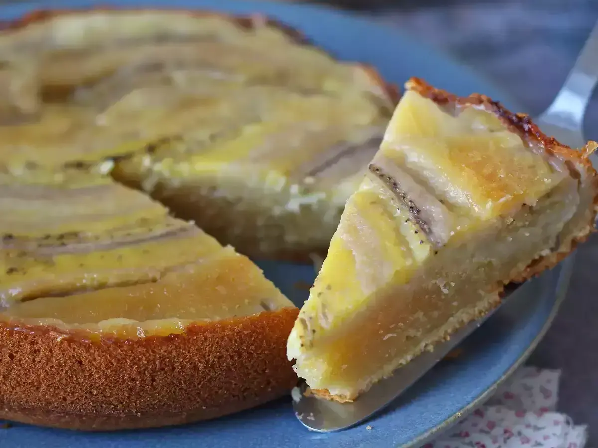 Un delicioso bizcocho de plátano, con una rebanada servida en un plato azul.