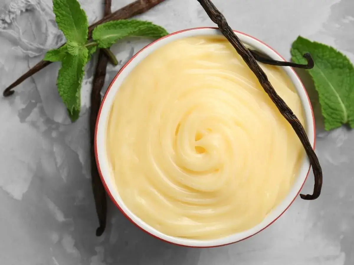 Crema pastelera sin azúcar, cremosa y suave, con vainas de vainilla y hojas de menta fresca.