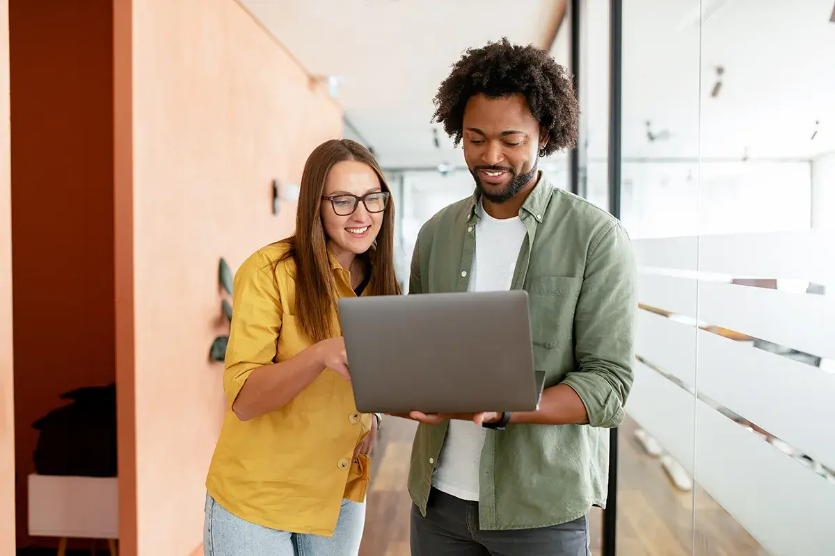 A woman and man discuss public administration vs public policy on a laptop.