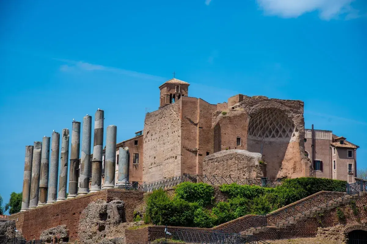 Resti antichi a Roma, tra cui colonne e mura di mattoni, evocano la grandezza della Domus Aurea.