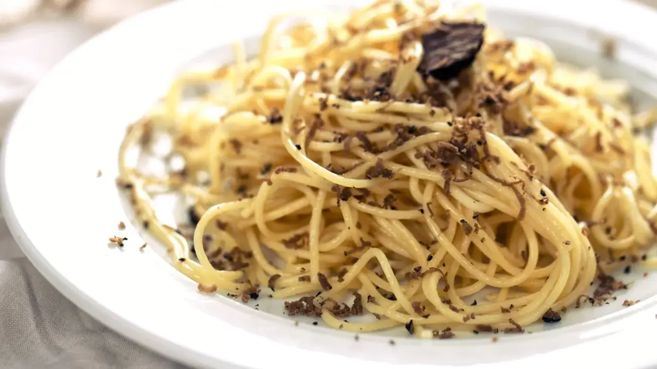 En tallrik med spaghetti, generöst toppad med finriven tryffel. Perfekt för en lyxig middag med ett gott vin till tryffelpasta.