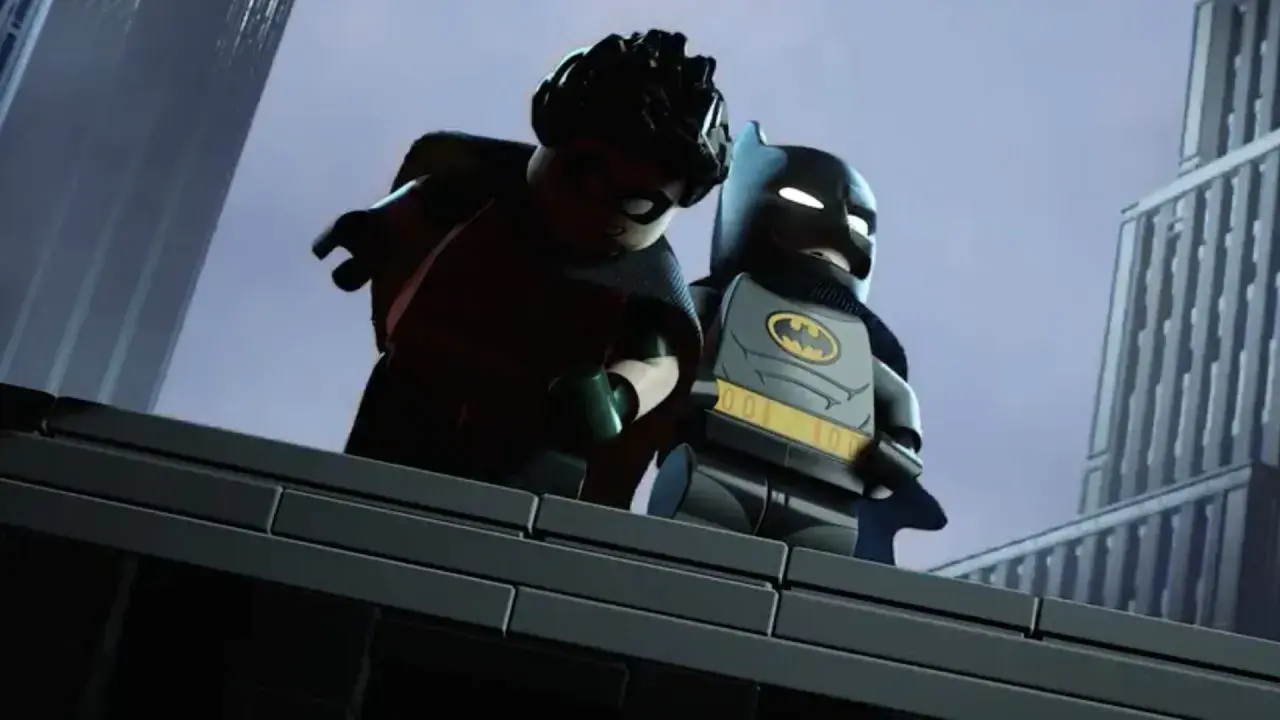Batman et Robin, en Lego, sur un toit. Batman semble donner une leçon à Robin.