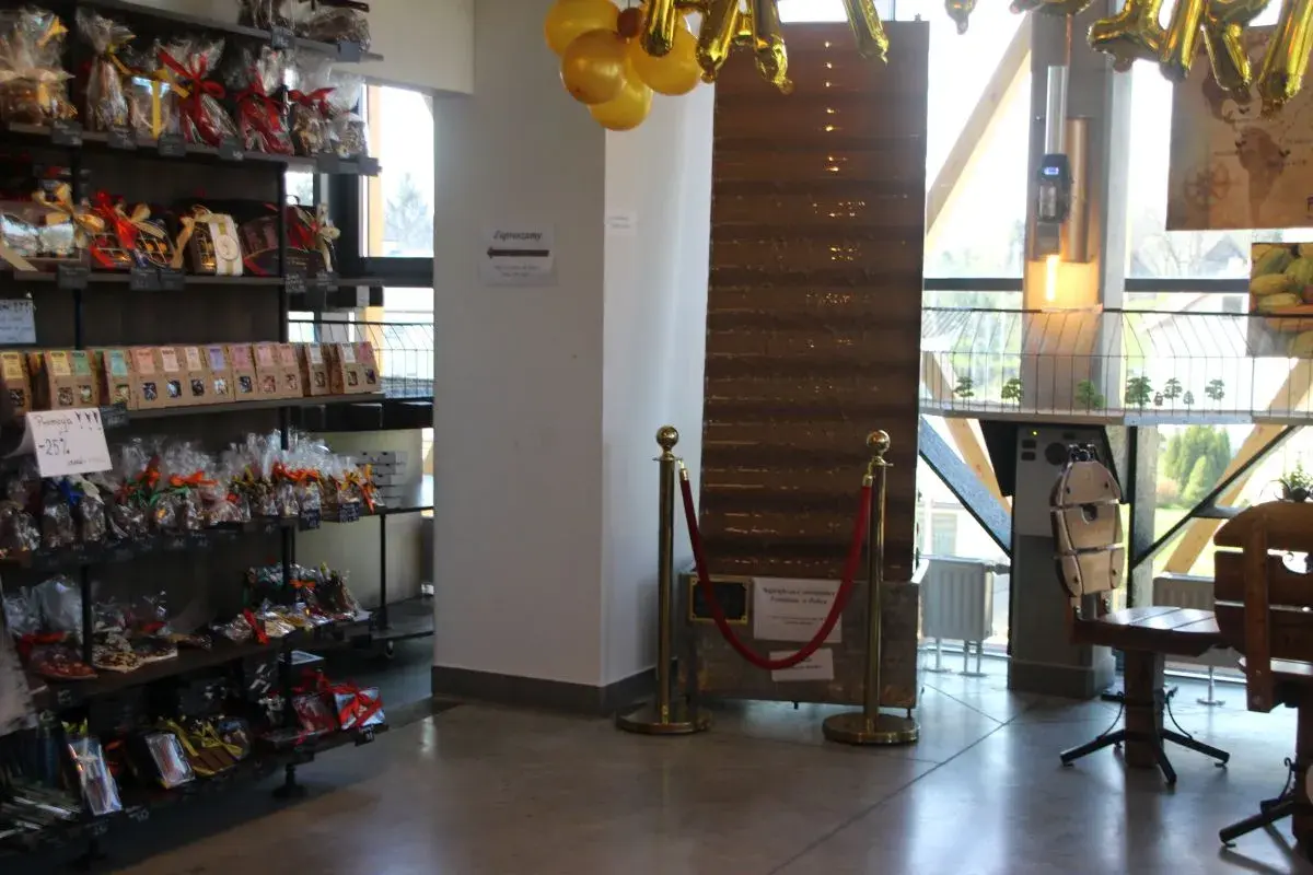 Wnętrze pijalni czekolady w Sanoku. Półki uginają się pod ciężarem słodkości, a złote balony zapowiadają wyjątkowe okazje.