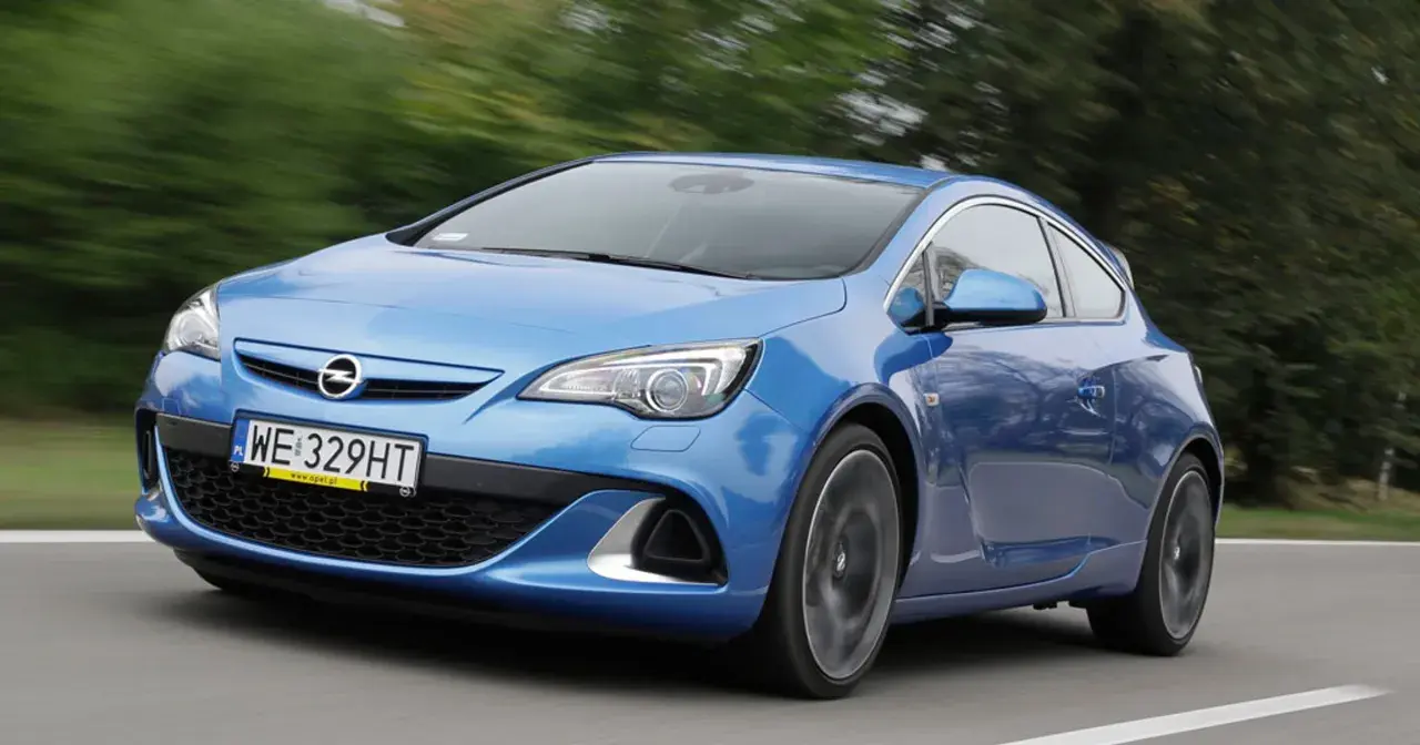 Niebieski Opel Astra G w ruchu, widok z przodu i z boku.