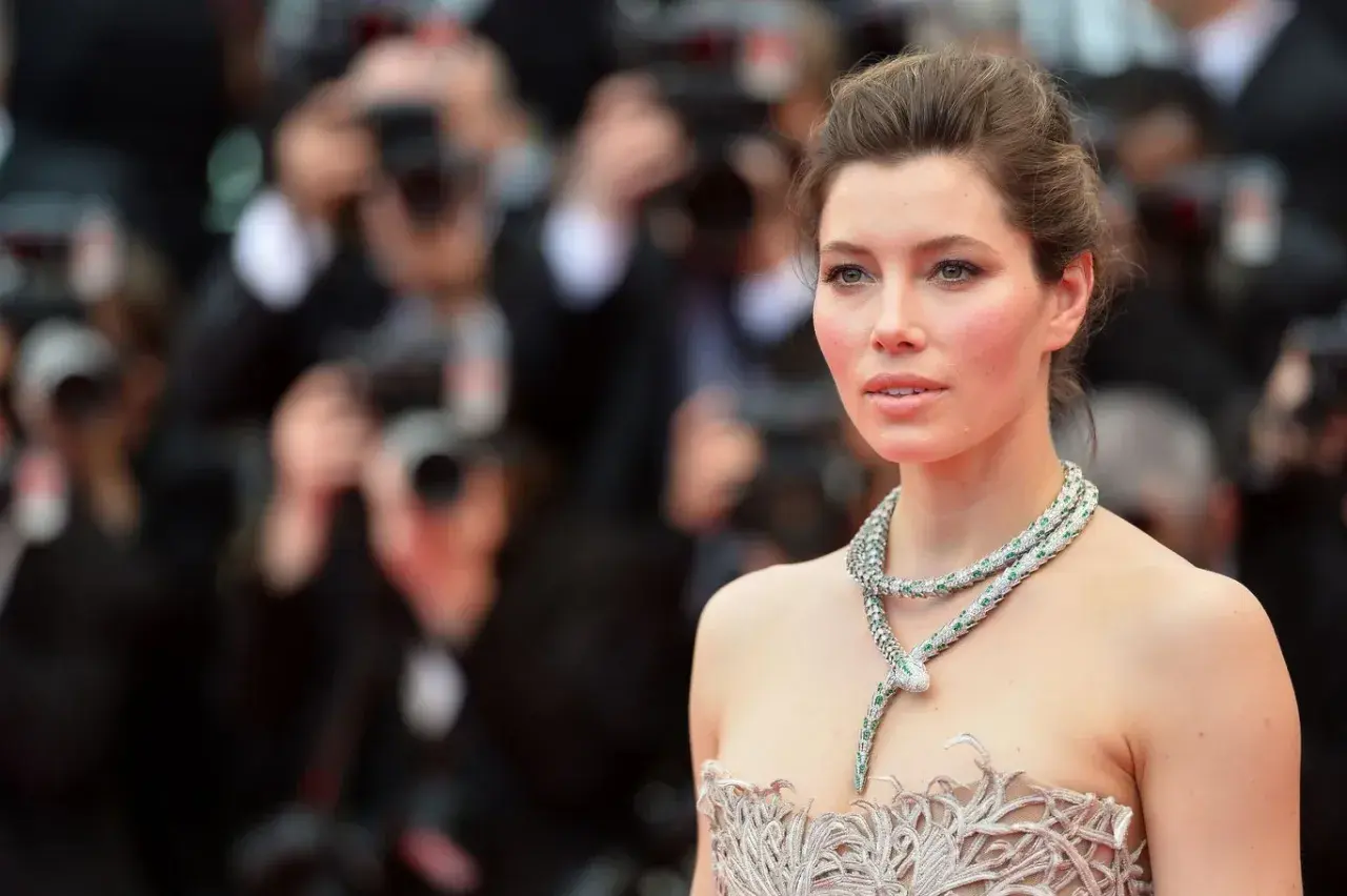 Jessica Biel w olśniewającej kreacji i biżuterii w kształcie węża, przypominającej sceny z jej filmów, pozuje na czerwonym dywanie.