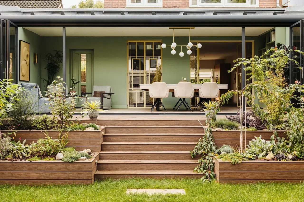 Schöne Ideen für einen kleinen Wintergarten: grüne Wände, bequeme Sitzmöbel und ein Essbereich mit moderner Beleuchtung.