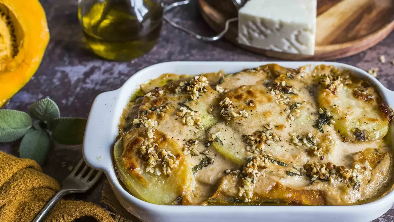 Piatto di patate e formaggio filante, un delizioso pecorino al forno con noci croccanti e erbe aromatiche.