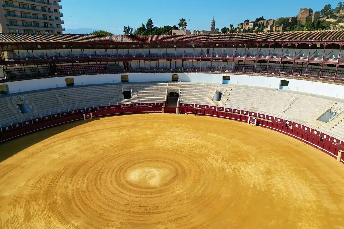 La plaza de toros de Málaga, con su arena dorada y gradas vacías, espera la próxima corrida.
