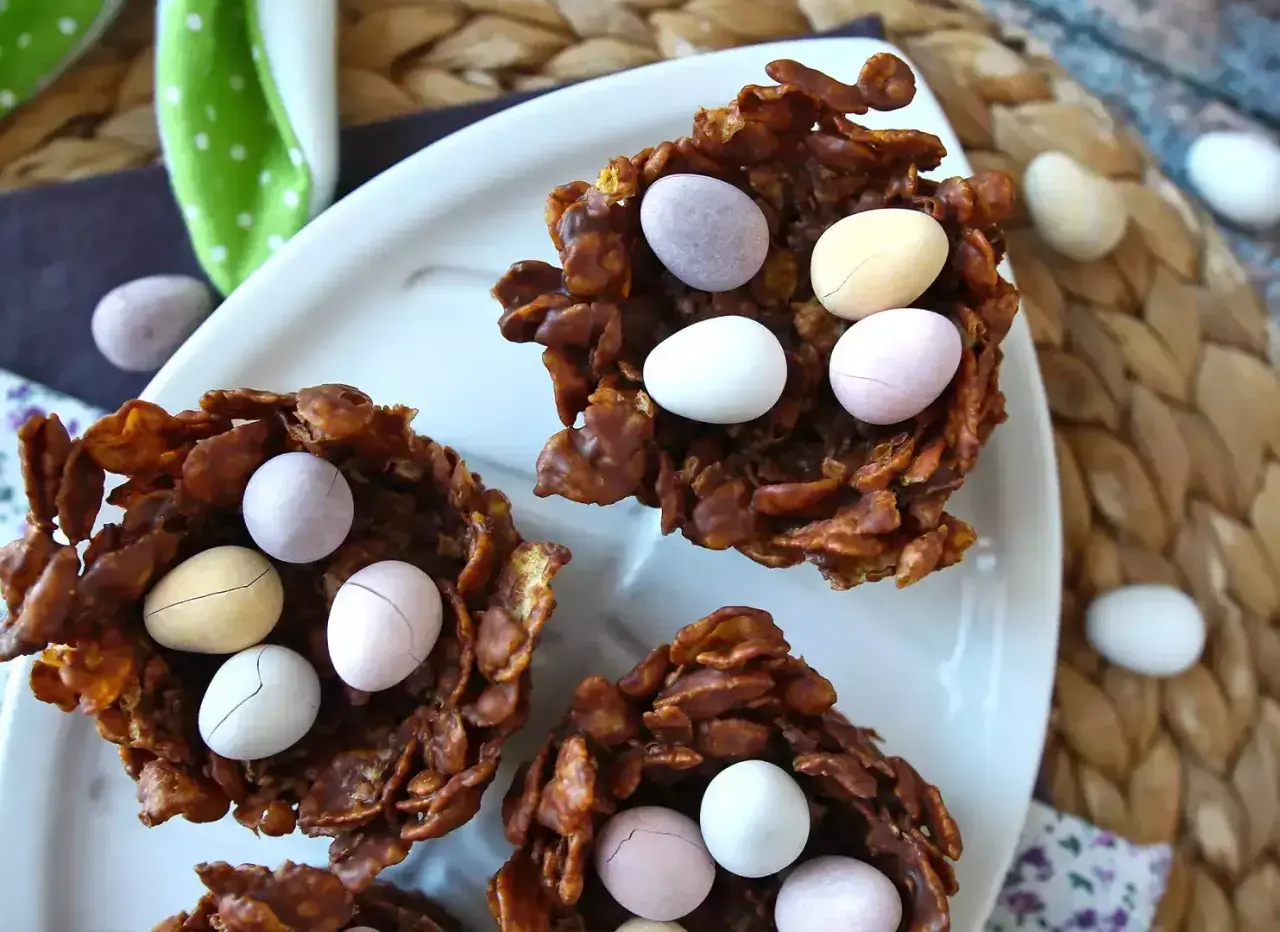 Délicieux nid de pâques en chocolat croustillant, garni d'œufs colorés. Parfait pour une chasse aux trésors gourmande.