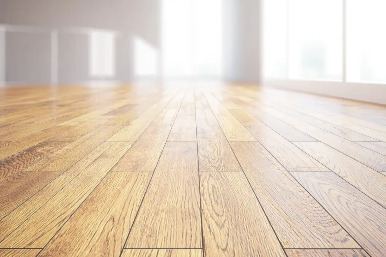 Pavimento in legno massiccio, con venature naturali che riflettono la luce. Un ambiente luminoso e accogliente.