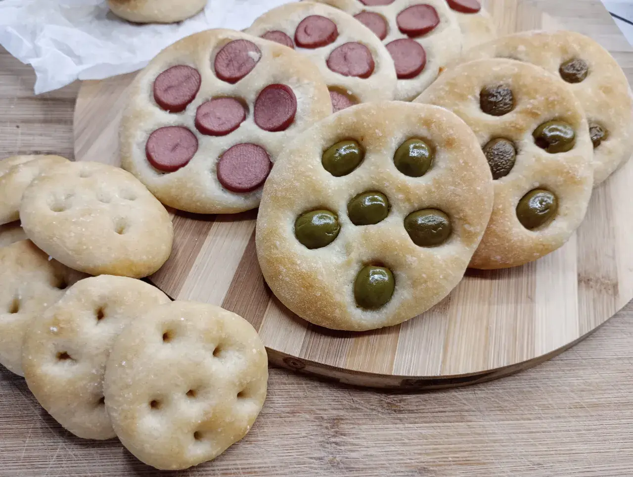 Focaccine di semola con olive e wurstel, pronte per essere gustate.