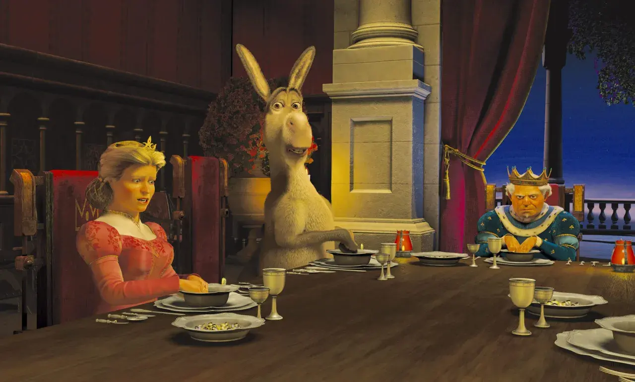 Królowa Fiona, Osioł i Król Harold przy stole. Scena z jednego z filmów DreamWorks.