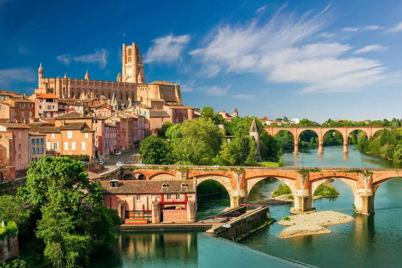 Vue d'Albi, une ville d'Occitanie, avec sa cathédrale imposante et ses ponts en briques sur le Tarn. Idéal pour savoir que faire en Occitanie.