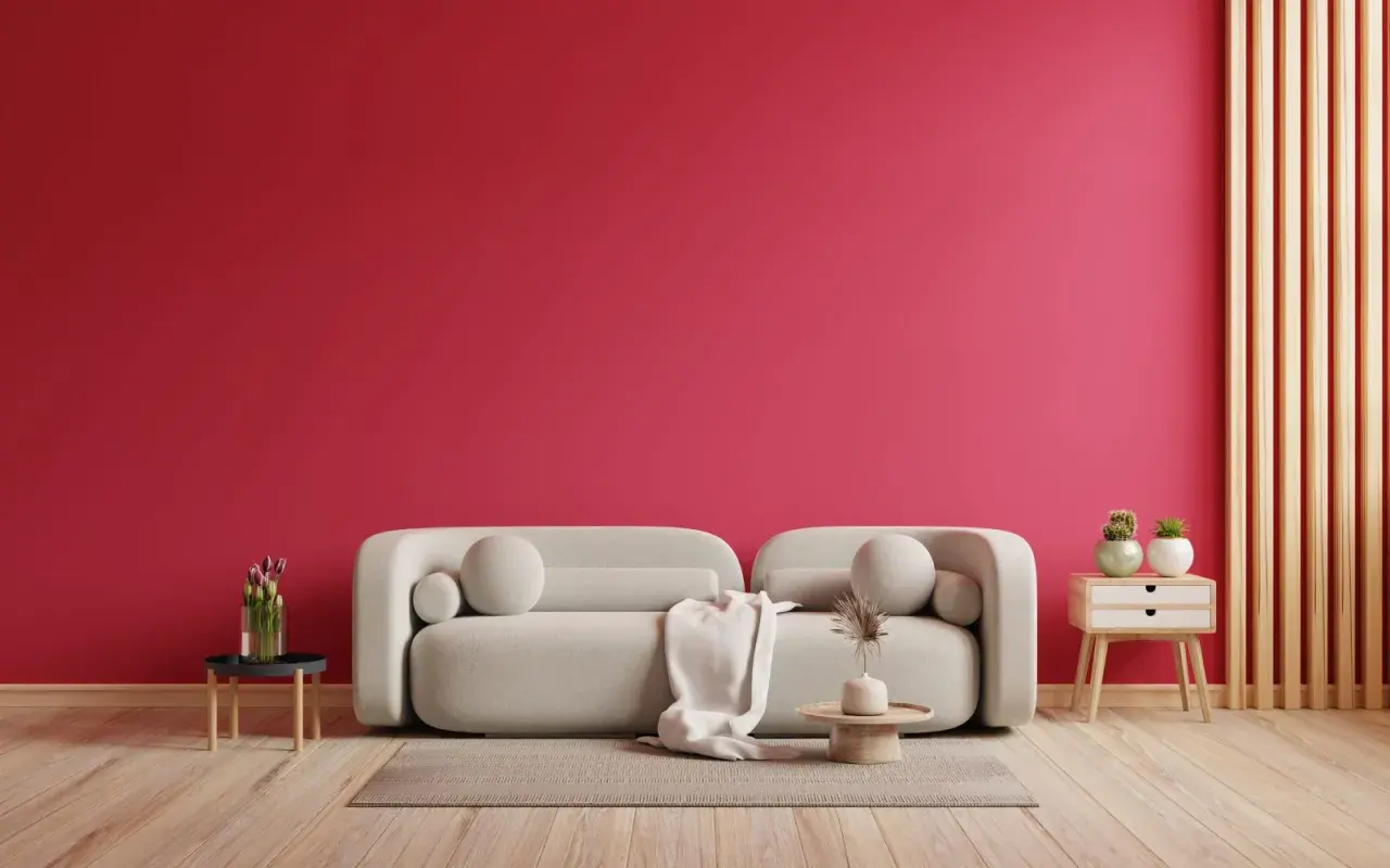 Ściana w kolorze magenta, jak to kolor! Jasna sofa, dywan, stolik z kwiatami i dekoracje.