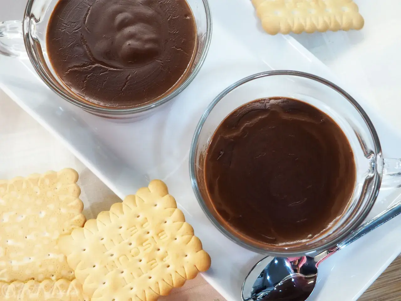 Due tazze di cioccolata calda fumante, accompagnate da biscotti secchi. Un momento di puro piacere.