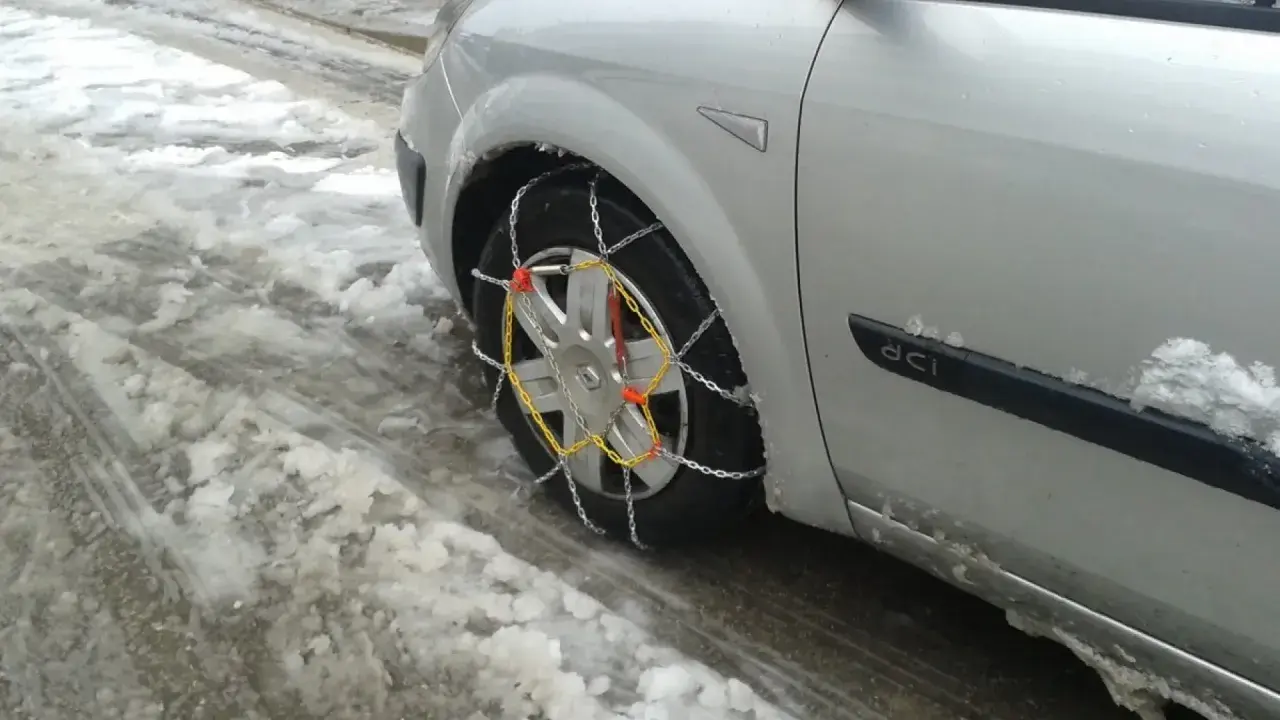 El coche está en la nieve, listo para circular cuando se ponen las cadenas de nieve.
