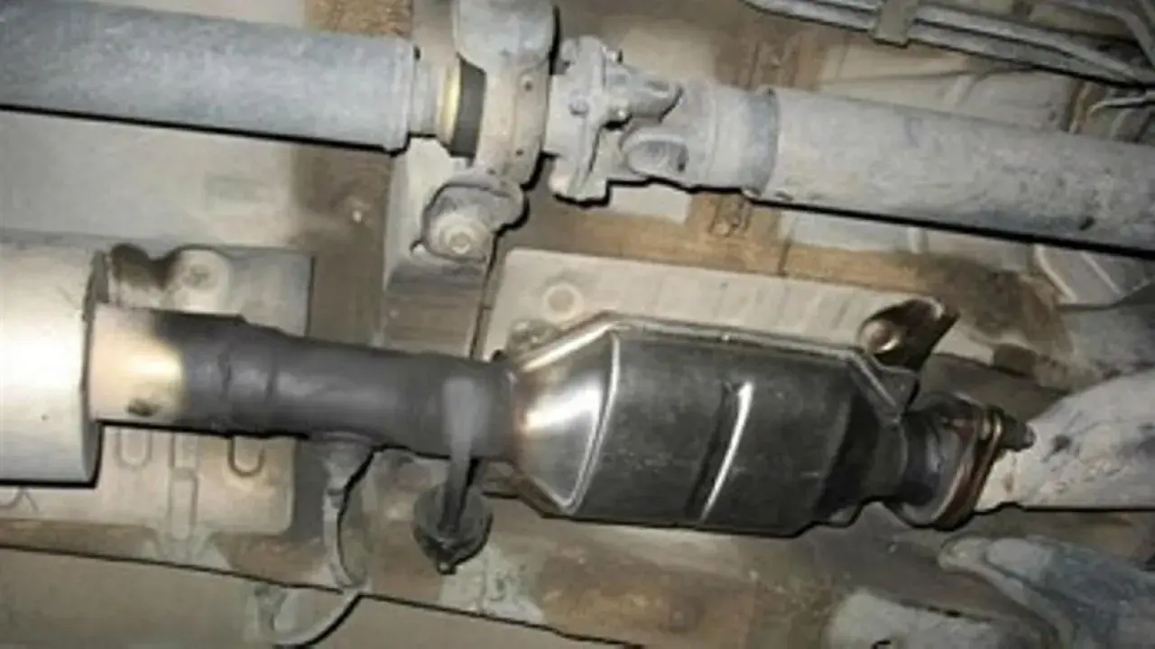 Sistema de escape de Renault con posible fallo DTC P0420. Se observa hollín en el tubo de conexión al catalizador.