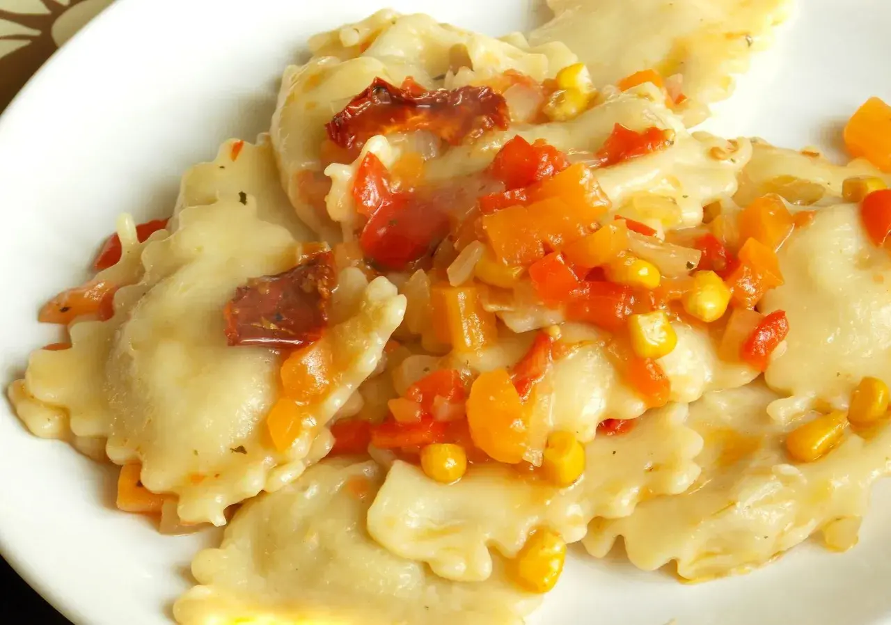 Ravioli z kolorowym sosem warzywnym, w tym kukurydzą i suszonymi pomidorami. Pyszny sos do ravioli.