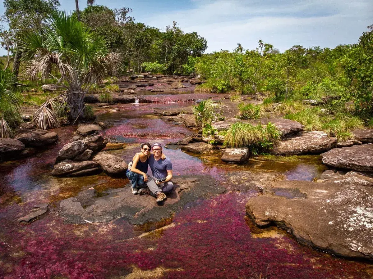 Un couple profite du Caño Cristales, la rivière aux cinq couleurs, une merveille à voir quand on se demande que faire en Colombie.