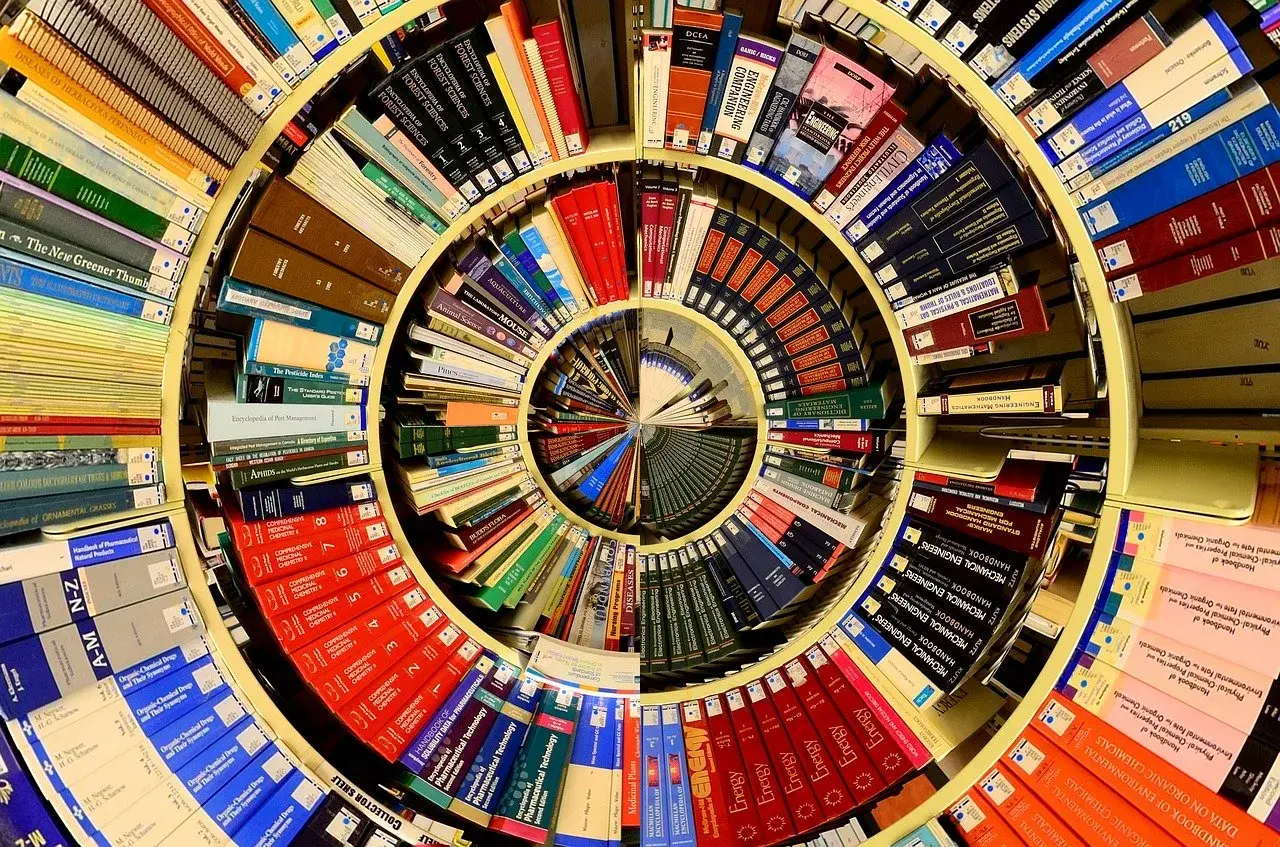 Książki ułożone w spiralę, tworząc okrąg. Wśród nich "piotr kościelny cykl mikun".