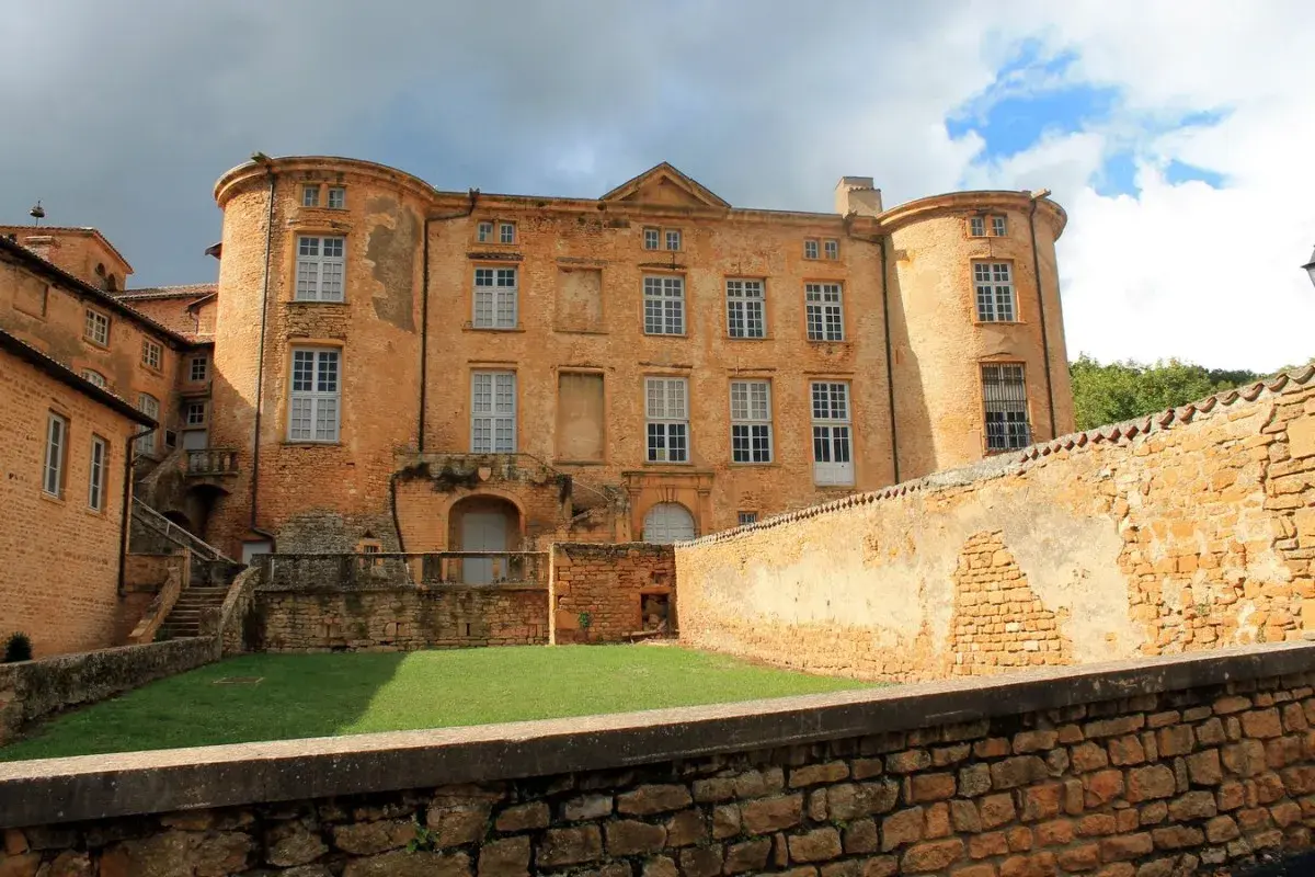 Château de Oingt, joyau du circuit des pierres dorées, se dresse fièrement sous un ciel orageux.