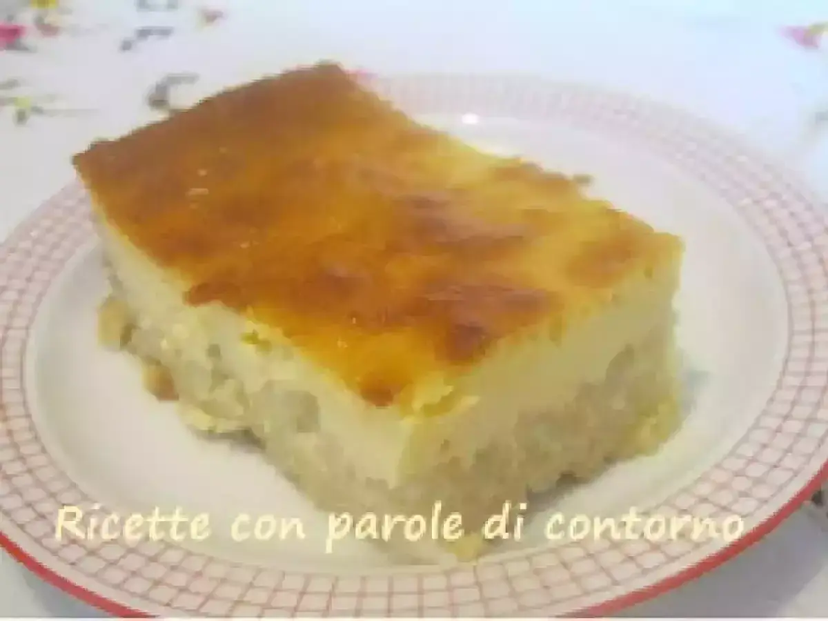 Una fetta di torta di riso carrarina, con una base soffice e una crema dorata in superficie, servita su un piatto a scacchi.