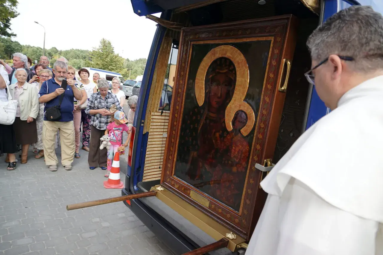 Obraz Matki Boskiej przygotowywany do peregrynacji. Ludzie zgromadzeni wokół, by zobaczyć święty wizerunek.