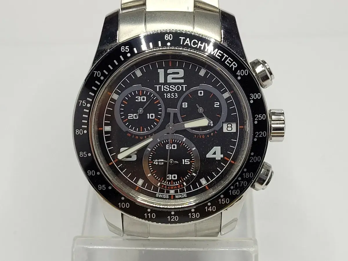 Reloj Tissot 1853 con cronógrafo y cristal de zafiro. Su esfera negra muestra la hora y los sub-diales, con un bisel taquimétrico.