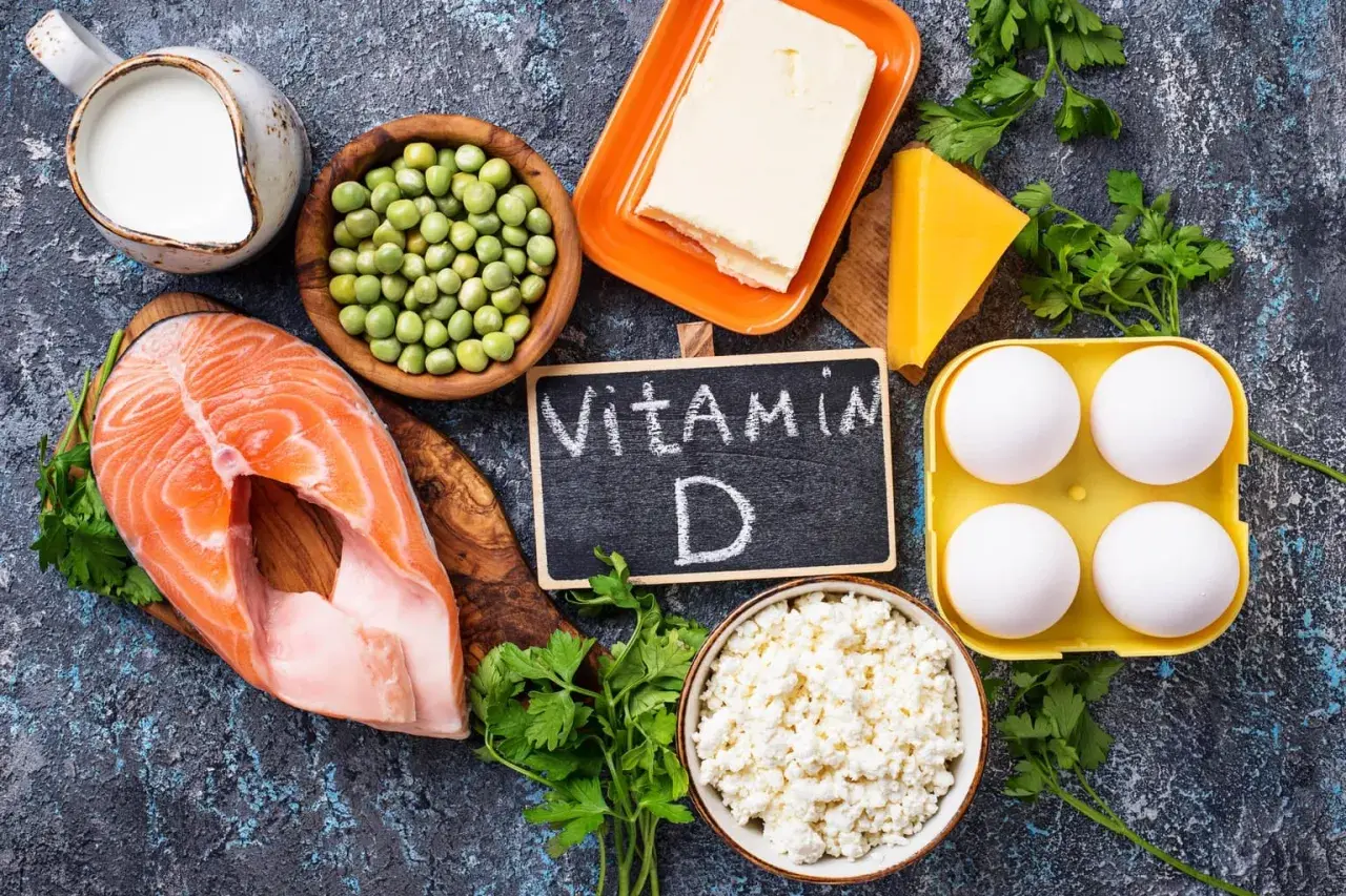 Ingredienti per come prendere la vitamina D: salmone, uova, latte, formaggio, piselli, burro e prezzemolo.