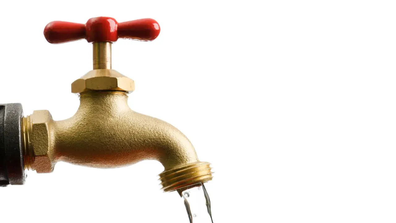 Messing-Wasserhahn mit rotem Griff, aus dem Wasser fließt. Bei Aquastop muss man den Wasserhahn zudrehen.