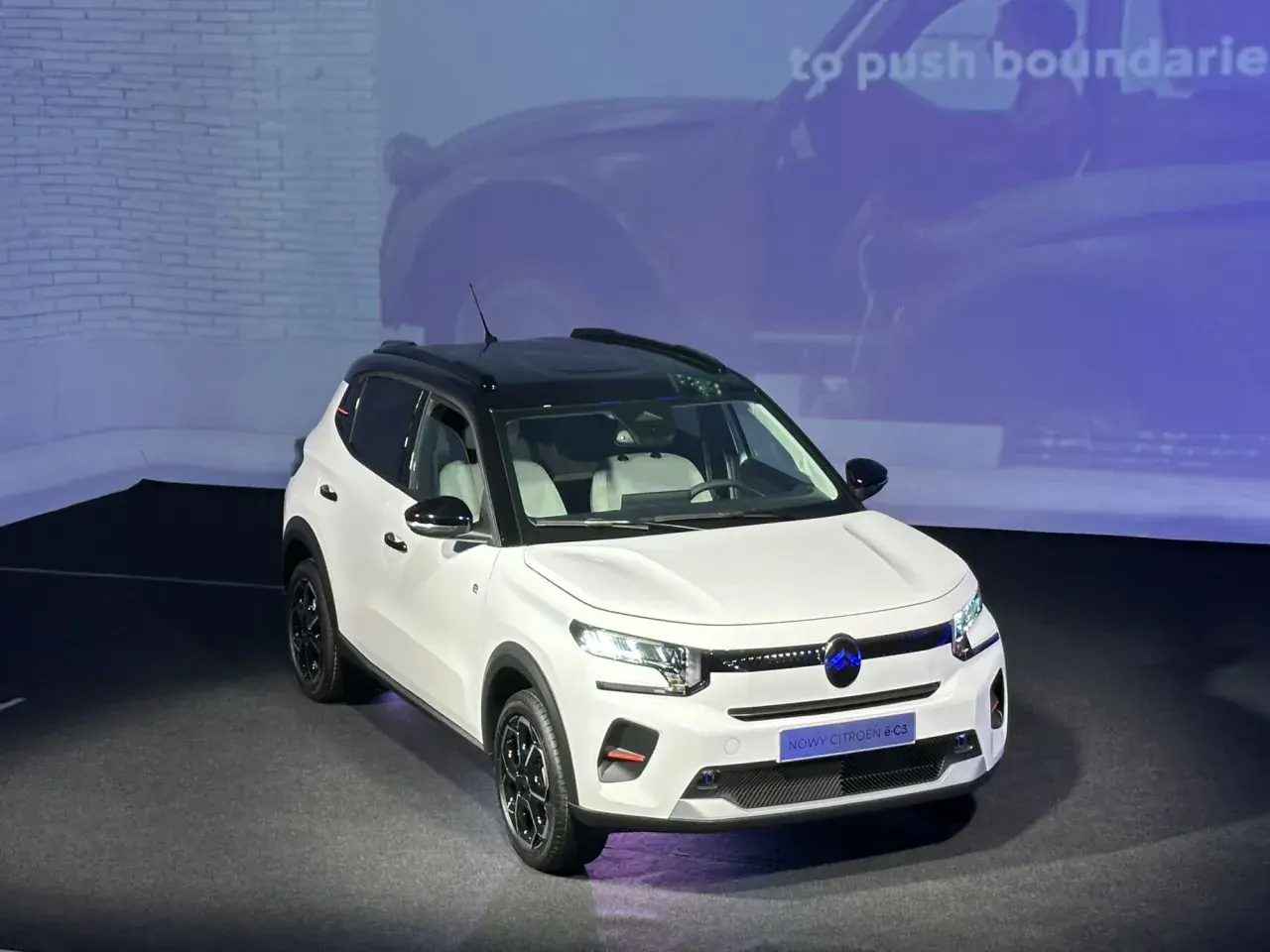 Nowy Citroën ë-C3 w białym kolorze z czarnym dachem prezentuje się nowocześnie. Idealny do miasta i na dalsze podróże.