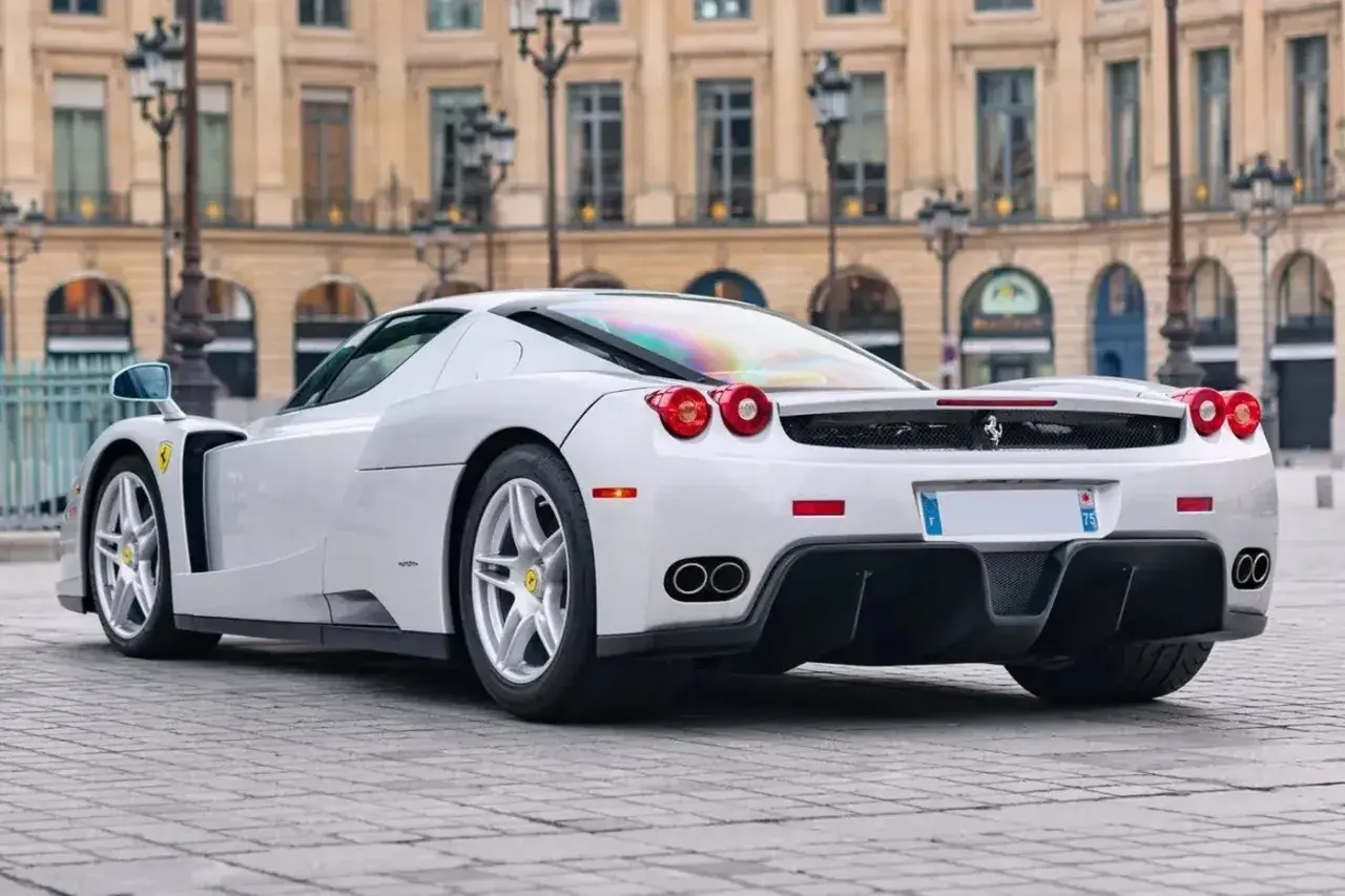 Białe Ferrari Enzo na bruku. Zastanawiasz się, ile kosztuje Ferrari Enzo? To marzenie wielu fanów motoryzacji.
