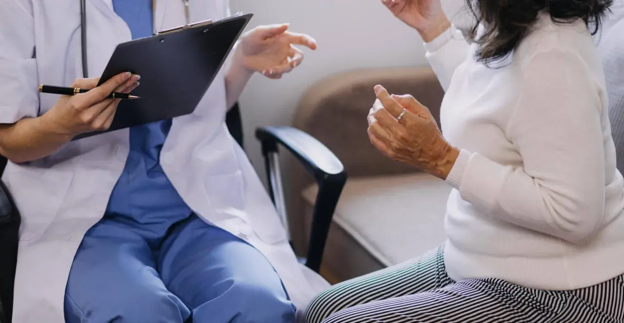 Lekarz w białym fartuchu rozmawia z pacjentką, notując coś na kartce. Czy do psychiatry potrzebne jest skierowanie?