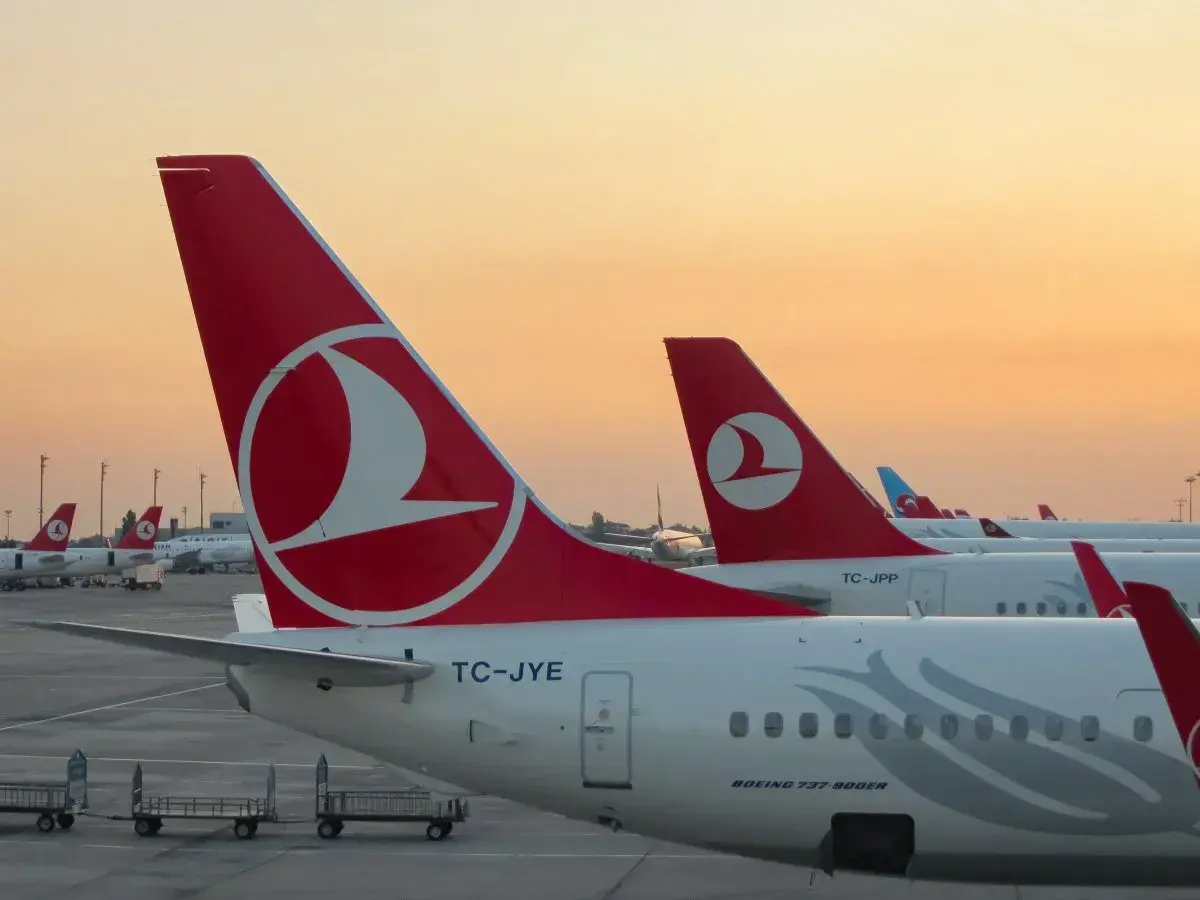 O zachodzie słońca samoloty Turkish Airlines czekają na pasażerów i ich bagaż.