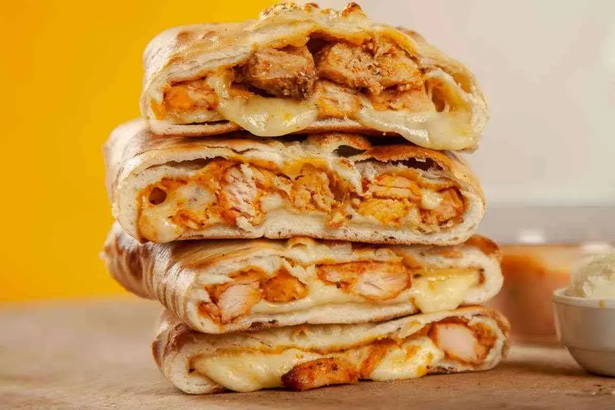 Scaccia ragusana ripiena di pollo e formaggio filante, un sapore unico.