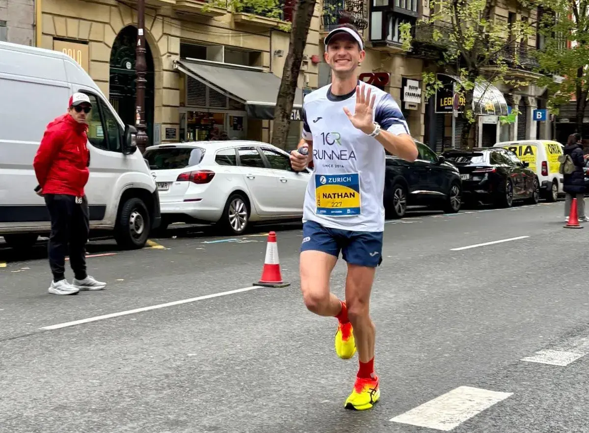 Nathan corre i 10 km in gara, salutando con la mano. Il tempo è ancora da definire, ma la sua energia è palpabile.