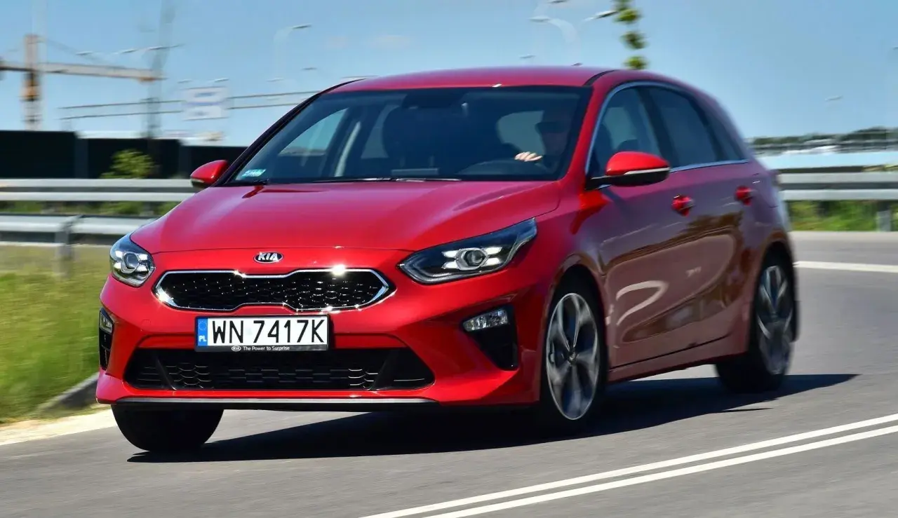 Czerwony Kia Ceed 1.4 benzyna w ruchu drogowym. Elegancki design i dynamiczna jazda.